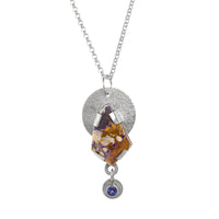 Hand fabricated, sterling silver pendant necklace featuring an 18x28mm boulder opal of purple, chocolate, copper and cream with a 5mm tanzanite highlighting the purple shades. 