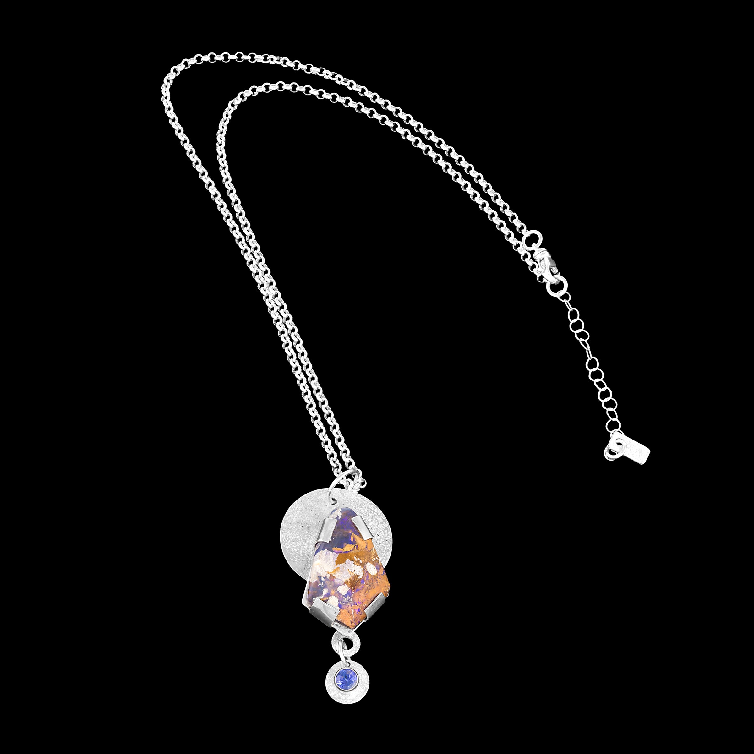 Hand fabricated, sterling silver pendant necklace featuring an 18x28mm boulder opal of purple, chocolate, copper and cream with a 5mm tanzanite highlighting the purple shades. 