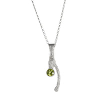 Handcrafted, one-of-a-kind pendant necklace featuring an organic casting of a twig in sterling silver, highlighted by a 6mm green peridot.