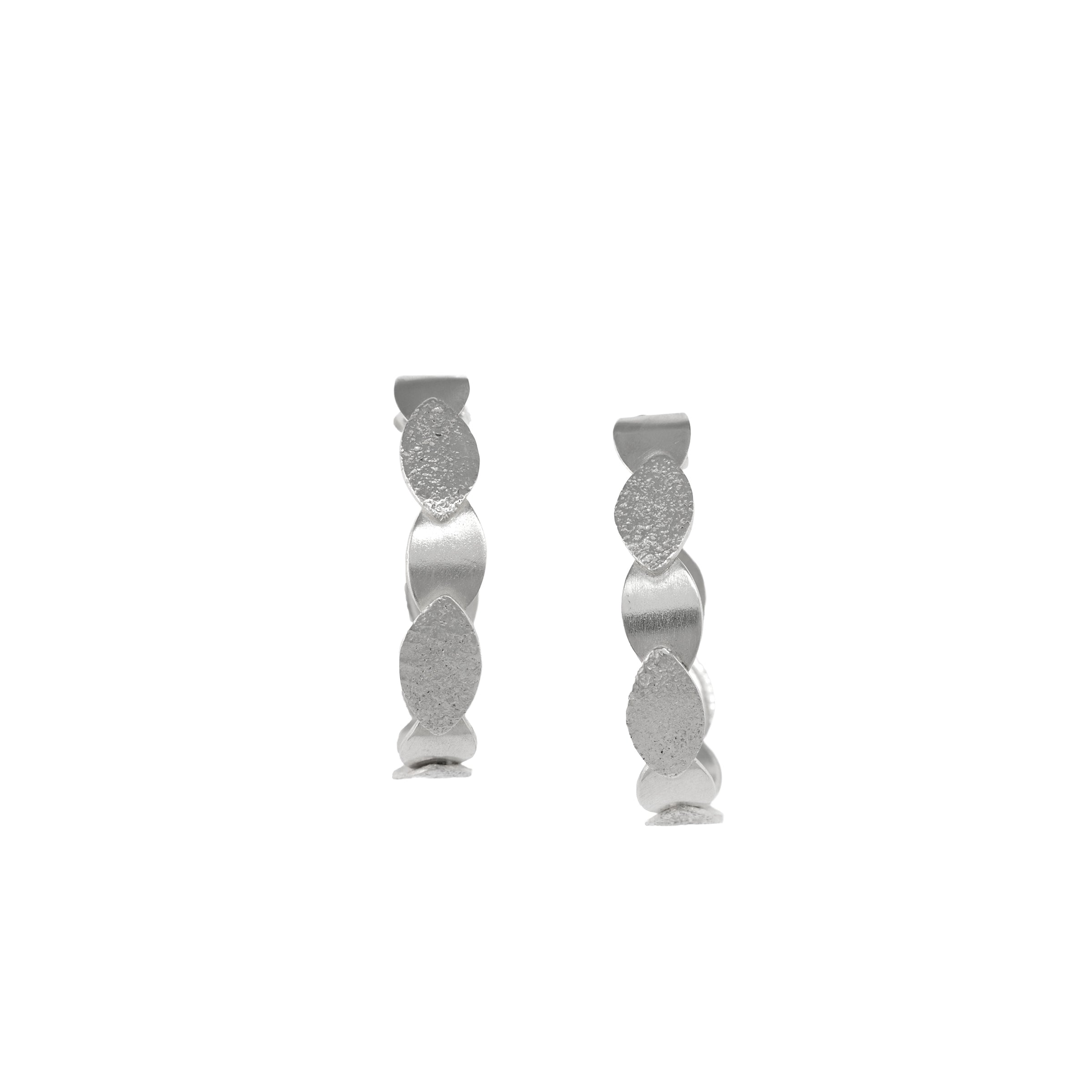 Hand-fabricated, sterling silver post hoops of textured and shiny leaves.
