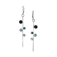 Contemporary linear drop earrings, hand-fabricated in sterling silver with asymmetrically arranged topaz gemstones in shades of blue.