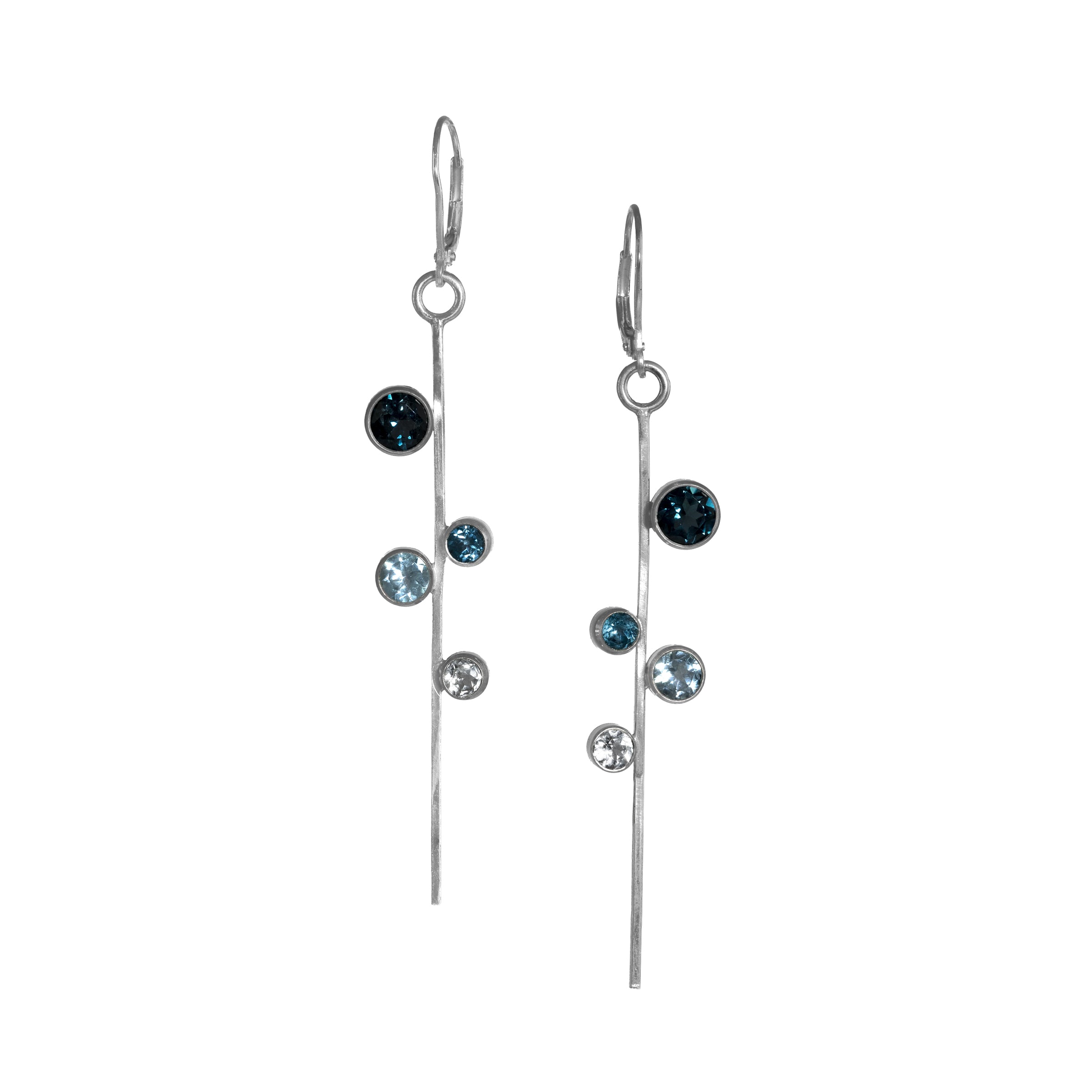 Contemporary linear drop earrings, hand-fabricated in sterling silver with asymmetrically arranged topaz gemstones in shades of blue.