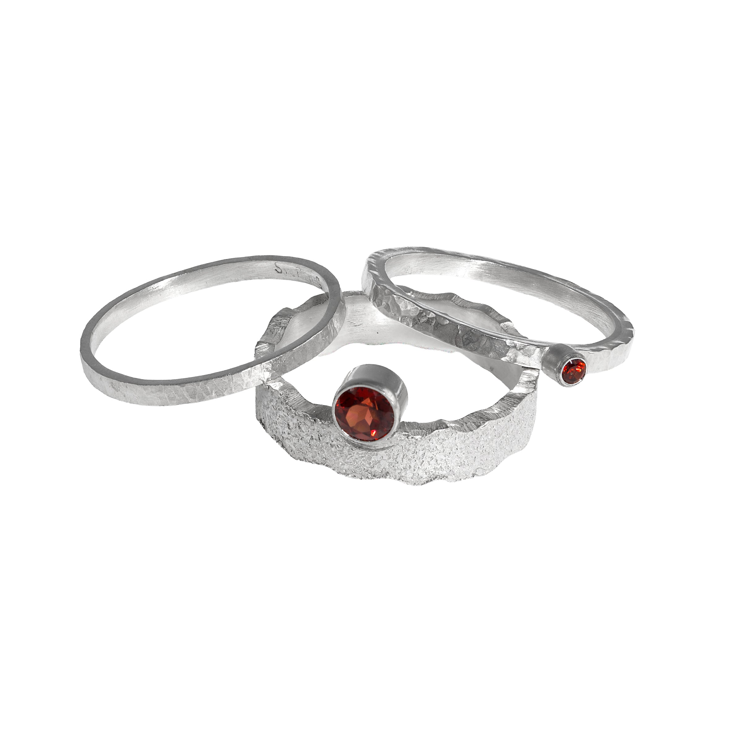 Hand-fabricated, sterling silver ring highlighted by a 4mm deep garnet red gemstone.  Shown with accent rings.
