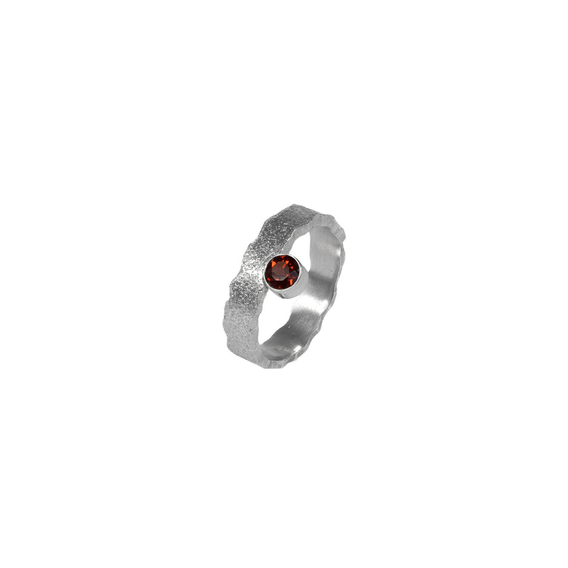 Hand-fabricated, sterling silver ring highlighted by a 4mm deep garnet red gemstone.