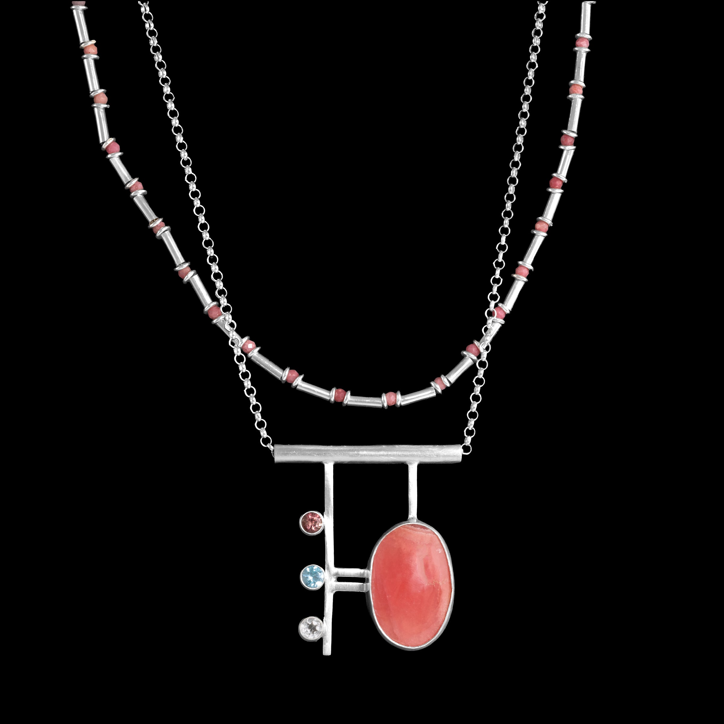 Contemporary, geometric design pendant necklace, hand-fabricated from sterling silver and featuring a large rhodochrosite cabochon highlighted with a pink tourmaline, blue zircon and white topaz.