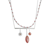 Handcrafted, contemporary pendant necklace in sterling silver and featuring a rhodochrosite cabochon, Oregon sunstone and 14K gold ball. 