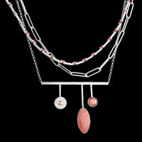 Handcrafted, contemporary pendant necklace in sterling silver and featuring a rhodochrosite cabochon, Oregon sunstone and 14K gold ball. 