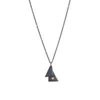 Oxidized argentium sterling silver and 18K gold charm pendant necklace with contemporary geometric styling in a layered look.