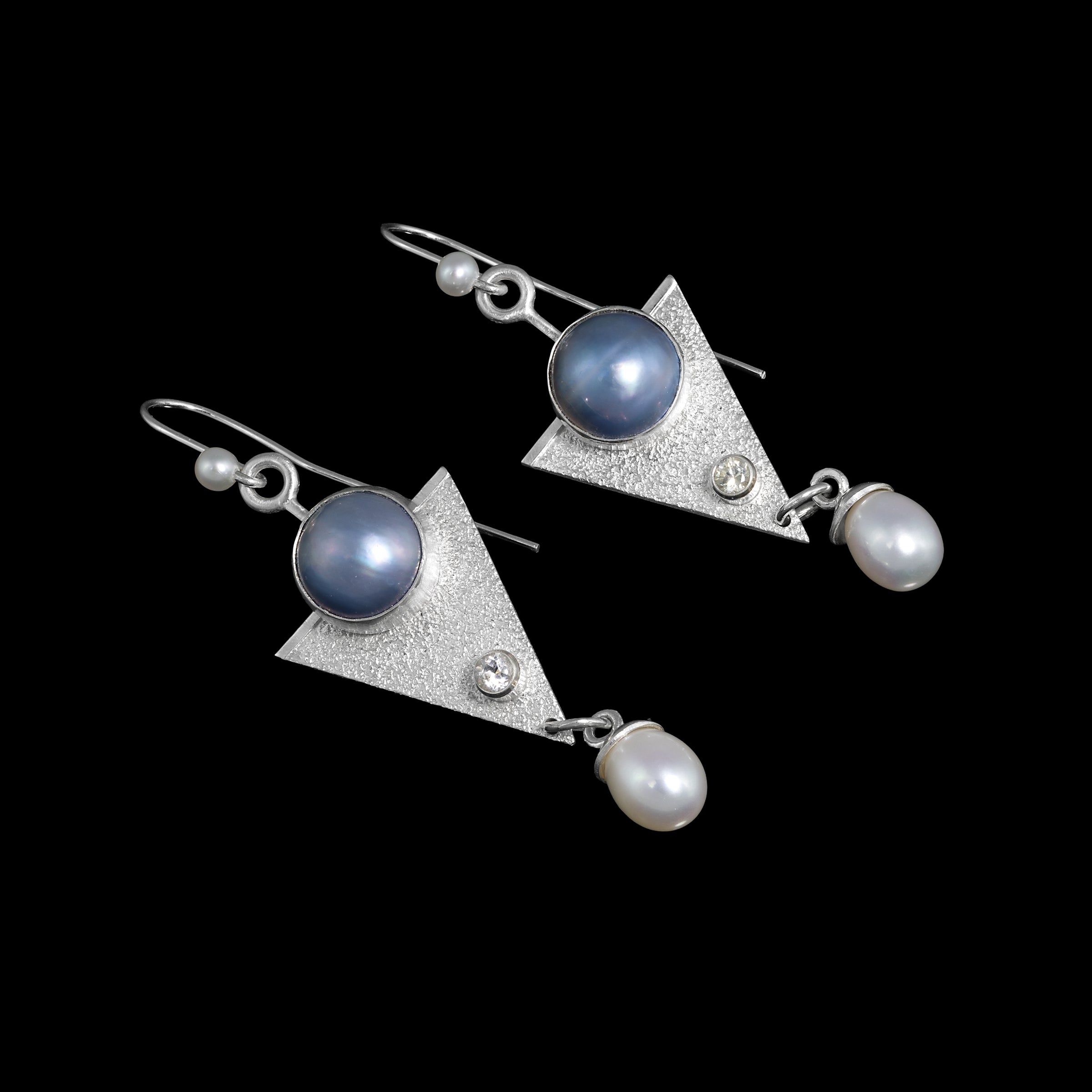 One-of-a-kind, dangle earrings in sterling silver featuring 10mm blue Mabe pearls, 4mm white topaz and 6mm white freshwater pearl drops.