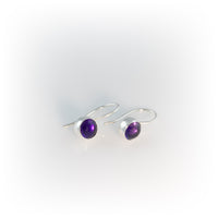 Petite drop earrings handcrafted in fine and sterling silver and set with a colorful stone – shown with amethyst (February birthstone).