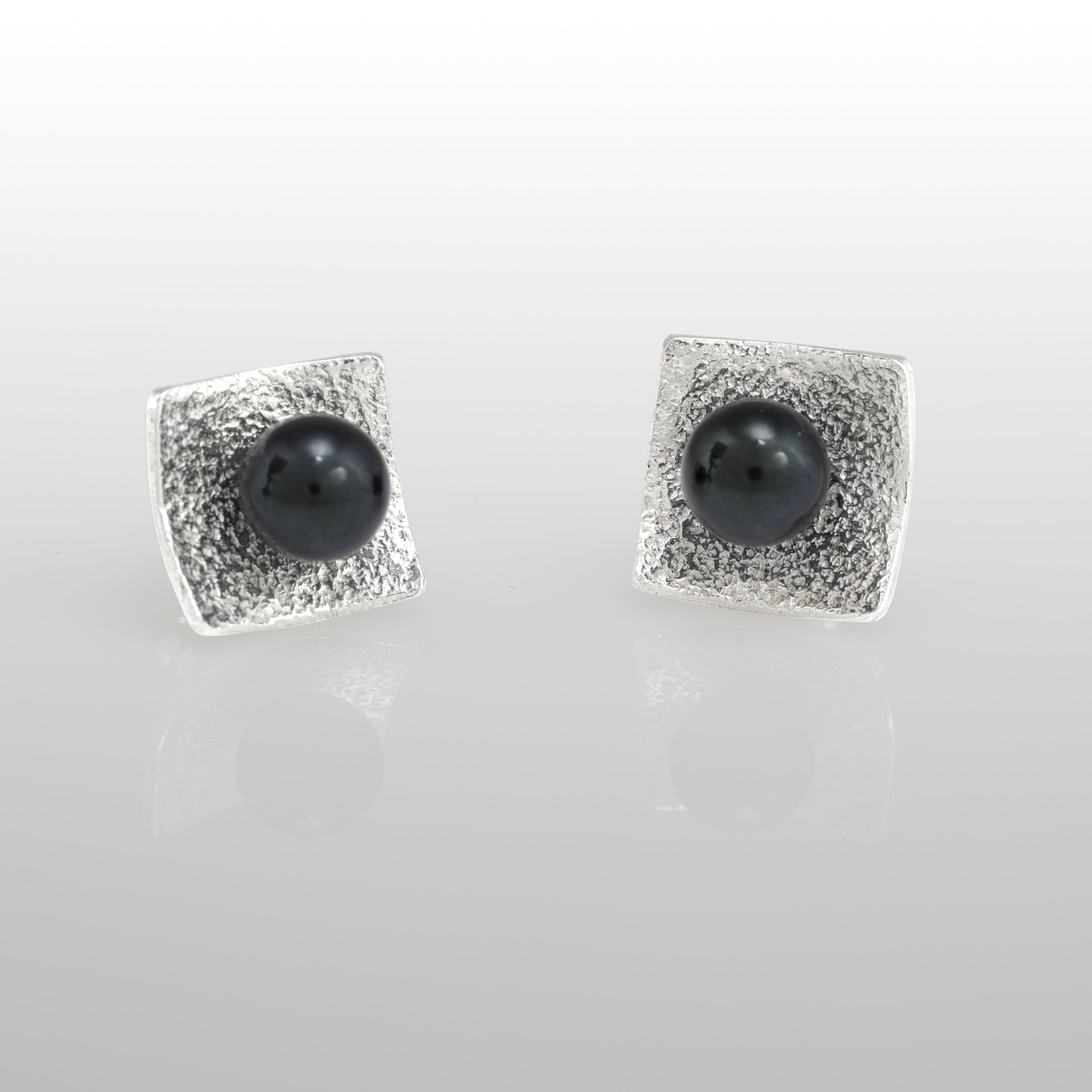 Hand-fabricated, post earrings in sterling silver with 6mm black pearls.