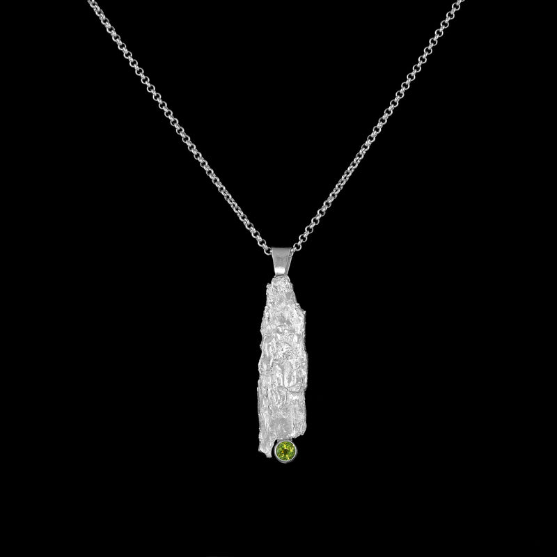 One-of-a-kind pendant necklace.  Handcrafted, organic casting of bark in sterling silver set with a bright green peridot (august birthstone) and hung on a silver rolo chain. 