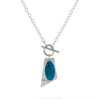 One-of-a-kind, lariat-style pendant necklace handcrafted in sterling silver around a stunning Ithaca Peak turquoise stone paired with a white sapphire.  Hand fabricated toggle clasp on a sterling silver oval chain.