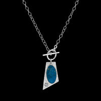 One-of-a-kind, lariat-style pendant necklace handcrafted in sterling silver around a stunning Ithaca Peak turquoise stone paired with a white sapphire.  Hand fabricated toggle clasp on a sterling silver oval chain.