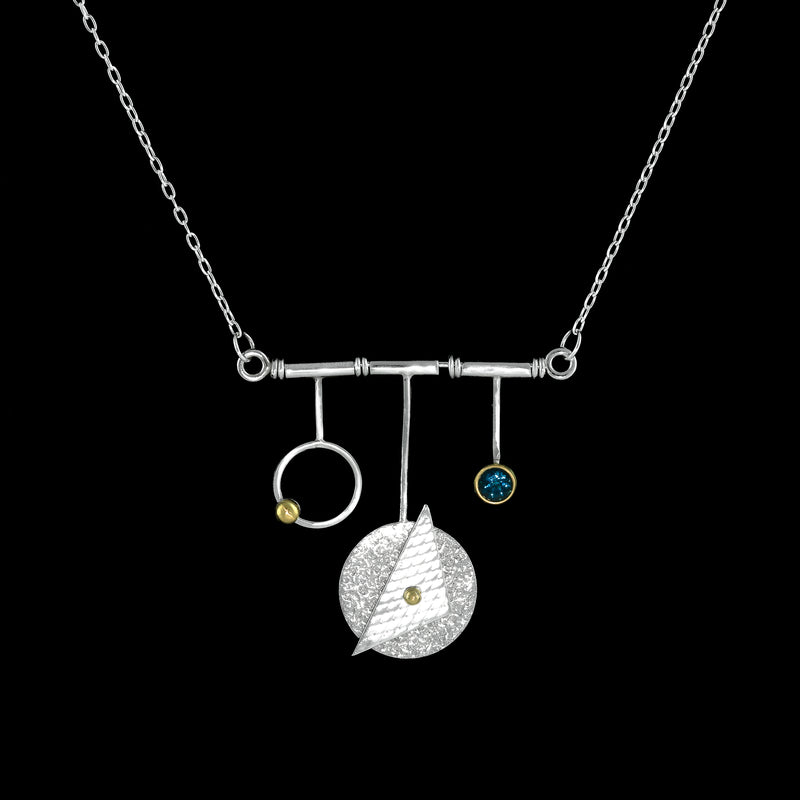 Modern geometric design pendant necklace, handcrafted from Argentium and sterling silver with 18K gold highlights and a London blue topaz set in an 18K gold bezel.