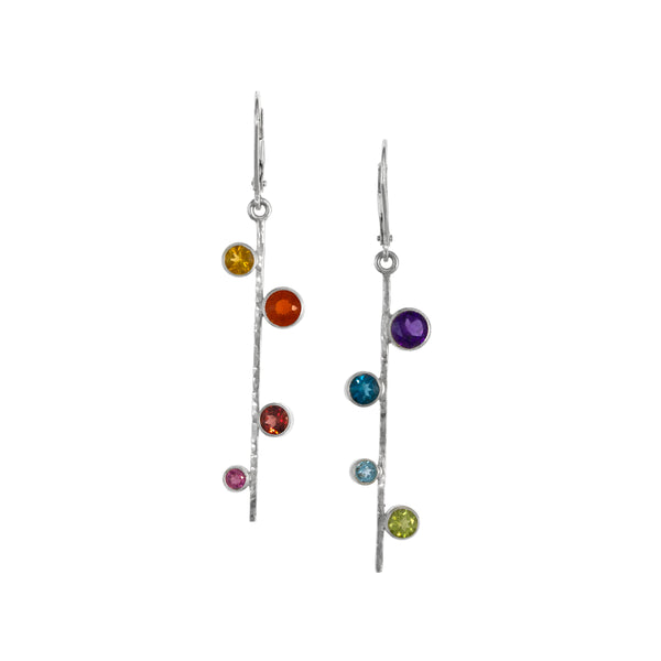 Asymmetrical, sterling silver earrings set with pride-themed faceted stones – pink tourmaline, red garnet, Mexican fire opal, golden citrine, green peridot, sky blue topaz, London blue topaz and purple amethyst.