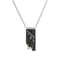 One-of-a-kind pendant necklace featuring a pyrite slab on a sterling silver base and adorned with a white topaz set in 14k gold and additional 14k gold elements.