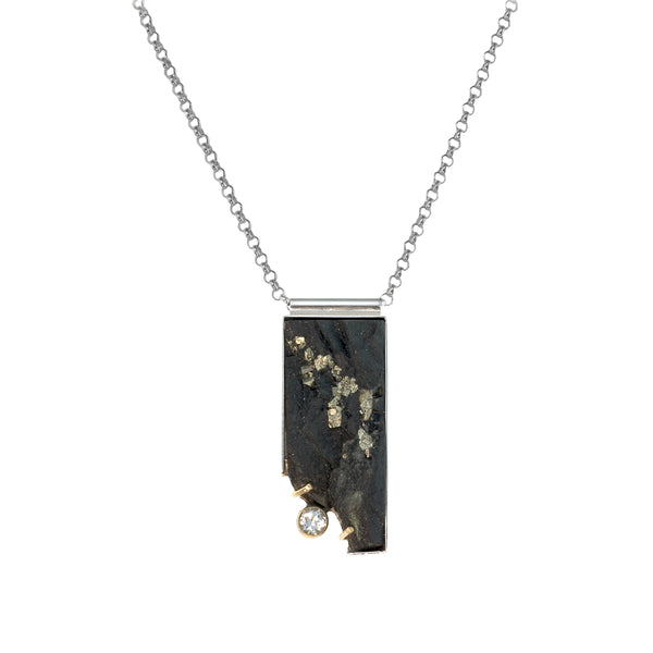 One-of-a-kind pendant necklace featuring a pyrite slab on a sterling silver base and adorned with a white topaz set in 14k gold and additional 14k gold elements.