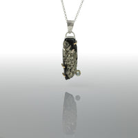 One-of-a-kind pendant necklace featuring a pyrite slab on a sterling silver base and adorned with a white topaz set in 14k gold and additional 14k gold elements.