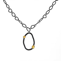 Modern design chain necklace with links individually hand-fabricated from oxidized Argentium sterling silver and 18K gold accents on the pendant.