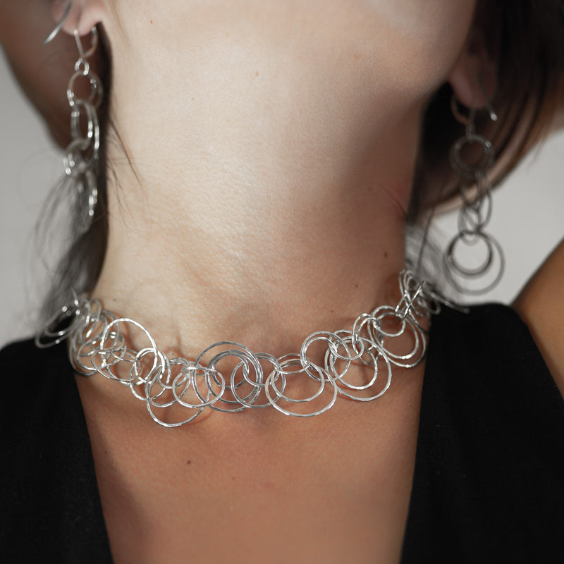 Statement necklace handcrafted from dozens of hammered rings of Argentium sterling silver.