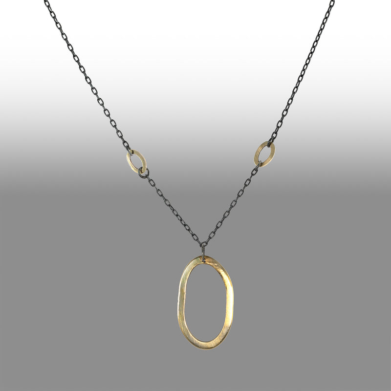 Large 14K yellow gold pendant on an oxidized sterling silver rolo chain highlighted by four smaller 14K gold links.