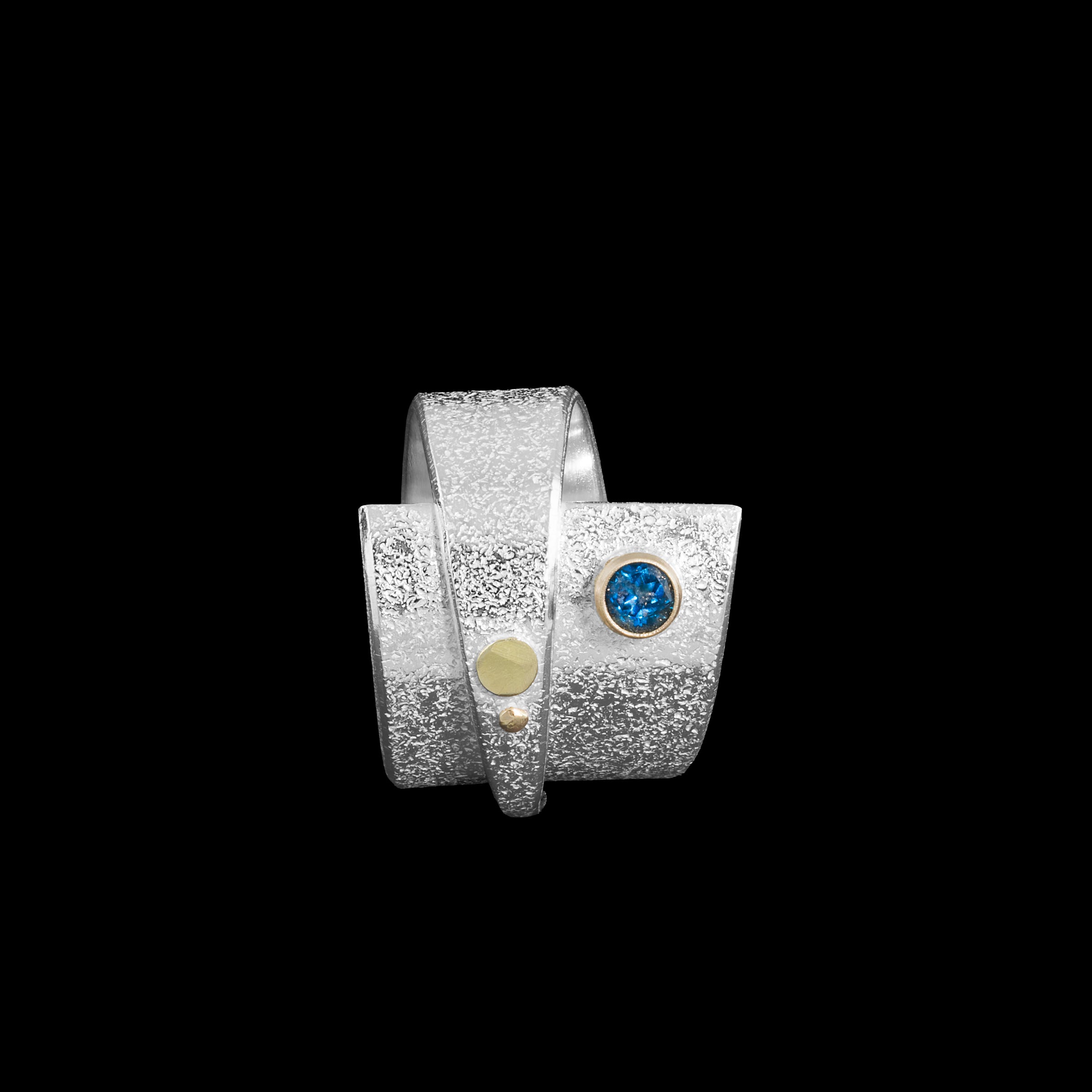 Contemporary sterling silver wrap ring with 14k gold elements and a 4mm London blue topaz set in 14k gold.