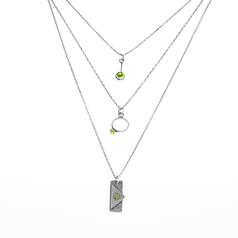 Oxidized argentium sterling silver and 18K gold charm pendant necklace with contemporary geometric styling in a layered look.