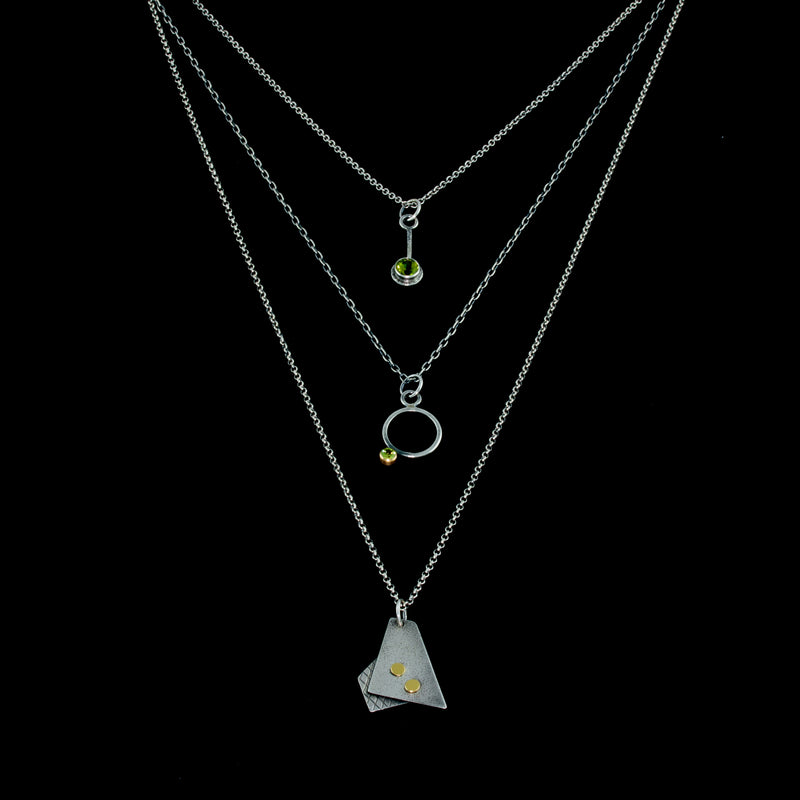 Oxidized argentium sterling silver and 18K gold charm pendant necklace with contemporary geometric styling.  Shown in a layered look.