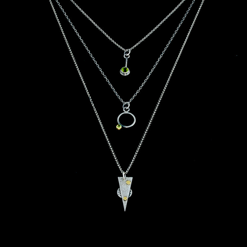 Oxidized argentium sterling silver and 18K gold charm pendant necklace with contemporary geometric styling. Shown in a layered look.