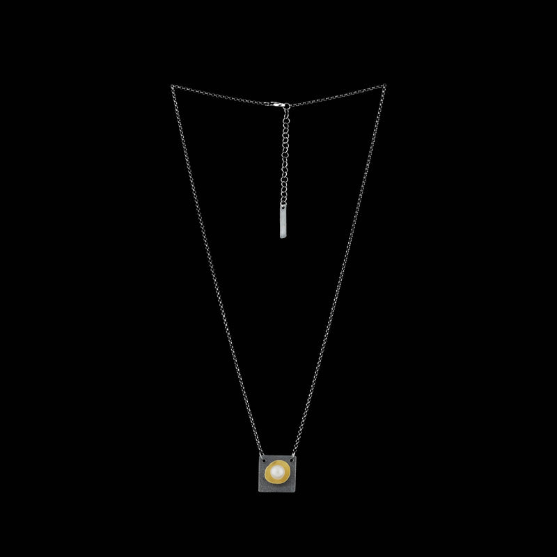 Contemporary pendant necklace handcrafted from oxidized Argentium and sterling silver highlighted with a freshwater pearl in an18K gold cup.  Silver chain.