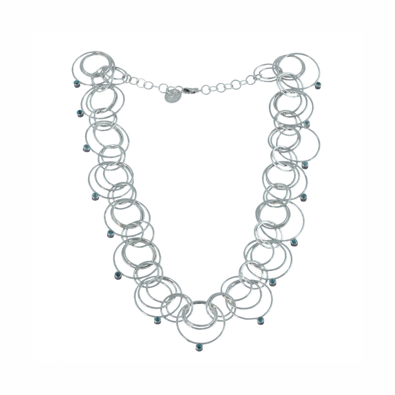 Statement necklace handcrafted from dozens of hammered rings of Argentium sterling silver and set with 15 3mm blue zircons.