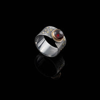 Van Gogh-inspired statement ring, handcrafted from oxidized sterling silver with 18K gold elements and an 8mm garnet surrounded by a 14K gold band.